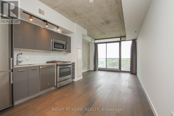 Open concept living area with a modern kitchen featuring grey cabinets and stainless steel appliances. - 1002 - 224 Lyon Street, Ottawa