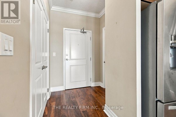 Apartment entrance hallway with a white door, closet doors, and dark wood floors. - 1002 - 240 Villagewalk Boulevard, London North