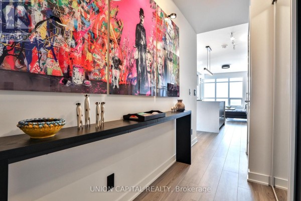 Hallway with a long black console table displaying art and decorative items. - 1002 - 30 Upper Mall Way, Vaughan
