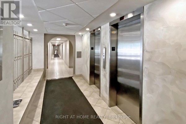 The building hallway with two elevators, tile flooring, and a long corridor in the distance. - 1002 - 40 Bay Mills Boulevard, Toronto