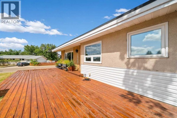 Side view of the house and deck with a large wooden deck. - 1002 13 Street Ne, Medicine Hat