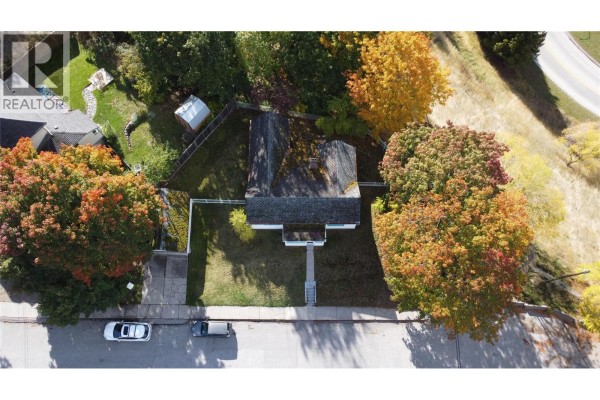 Top-down aerial view of a white house with trees and a street. - 1002 Kootenay Street, Nelson