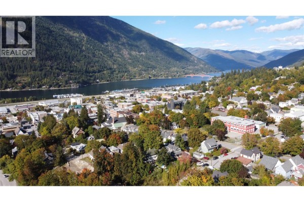 View of a town and a lake surrounded by mountains, with houses in the foreground. - 1002 Kootenay Street, Nelson