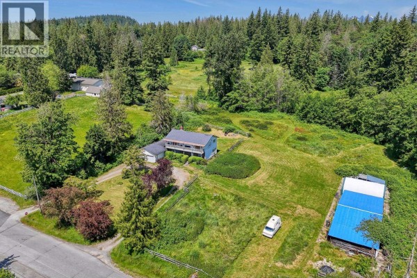 Aerial view of a sprawling property with a house, outbuildings, and wooded areas. - 10022 Rolley Crescent, Maple Ridge