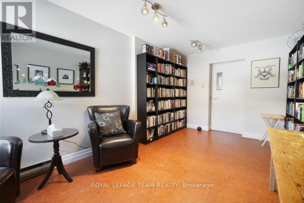 Leather armchair, bookshelves, and mirror in a room - 1004 - 40 Arthur Street E Ottawa