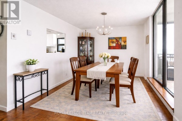 Dining room with wooden table, chairs, china cabinet, and chandelier - 1004 - 40 Arthur Street E Ottawa