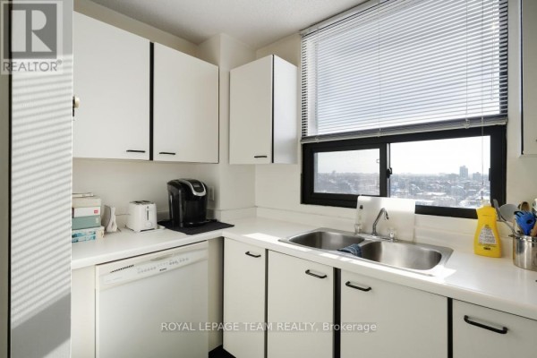Kitchen with white cabinets, double sink, toaster, coffee maker, dishwasher, and city view - 1004 - 40 Arthur Street E Ottawa