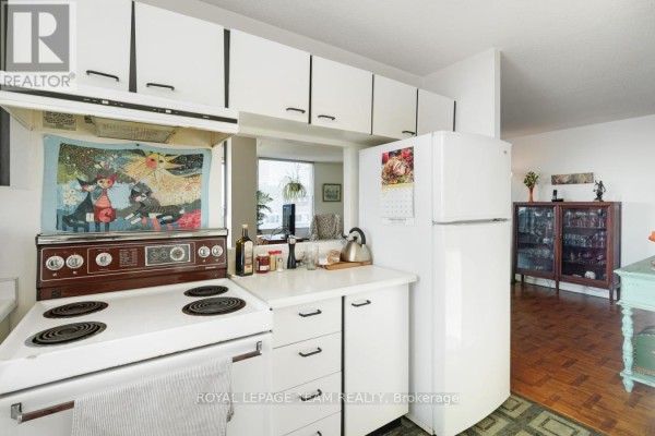 Retro kitchen with white cabinets, vintage stove, and display cabinet - 1004 - 40 Arthur Street E Ottawa