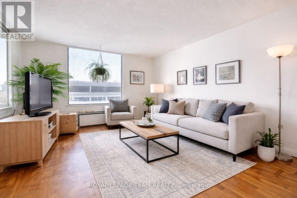 Living room with sofa, armchair, coffee table, and TV - 1004 - 40 Arthur Street E Ottawa