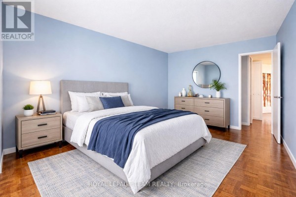 King bed with blue blanket, nightstands & dresser with mirror - 1004 - 40 Arthur Street E Ottawa