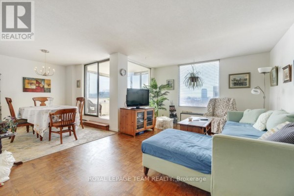 Living room with dining area, sofa, TV, and city view - 1004 - 40 Arthur Street E Ottawa