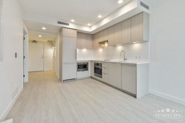 Apartment kitchen with light wood cabinets, stainless steel appliances, and white countertops. - 1004 13675 107a Avenue, Surrey
