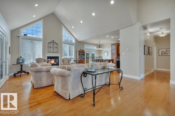 Spacious living room with a fireplace, vaulted ceiling, and large windows. - 10043 Twp Road 452, Rural Wetaskiwin County