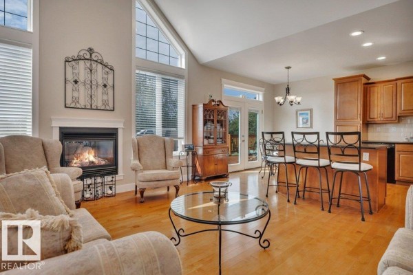 Living area with fireplace and seating, open to a kitchen with island seating. - 10043 Twp Road 452, Rural Wetaskiwin County