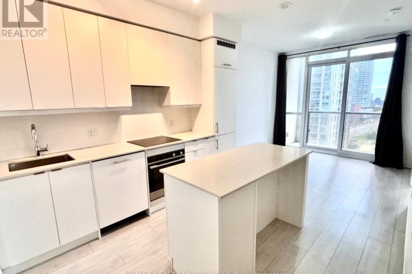 View of an open-concept kitchen and living area with large windows and city views. - 1005 - 30 Elm Drive W, Mississauga