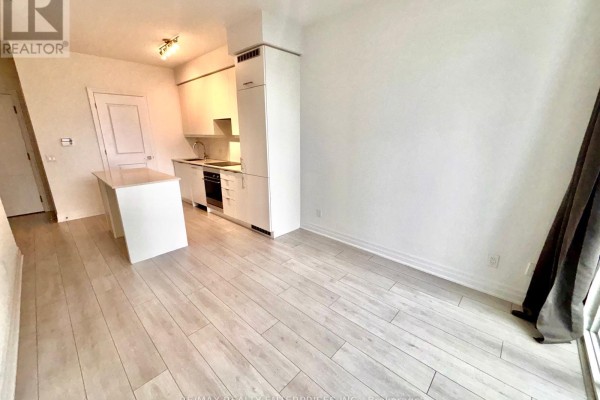Interior view of a bright living space with light wood floors and white walls. - 1005 - 30 Elm Drive W, Mississauga