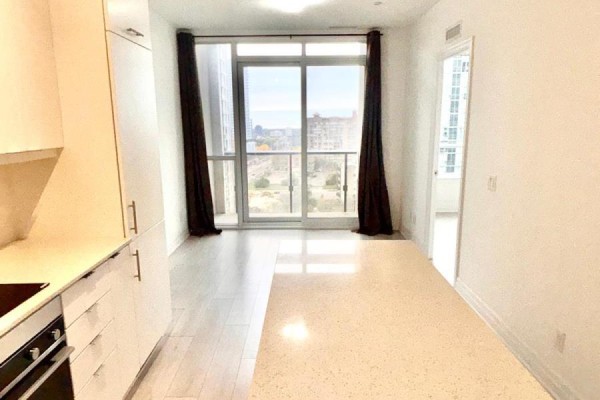 View from the kitchen and living area towards a balcony with city and parkland views. - 1005 - 30 Elm Drive W, Mississauga
