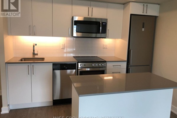Kitchen with white cabinets, stainless steel appliances, and an island with grey countertop. - 1005 - 38 Monte Kwinter Court, Toronto