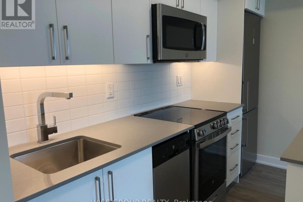 Close-up of a kitchen counter with stainless steel sink, faucet, and stovetop. - 1005 - 38 Monte Kwinter Court, Toronto