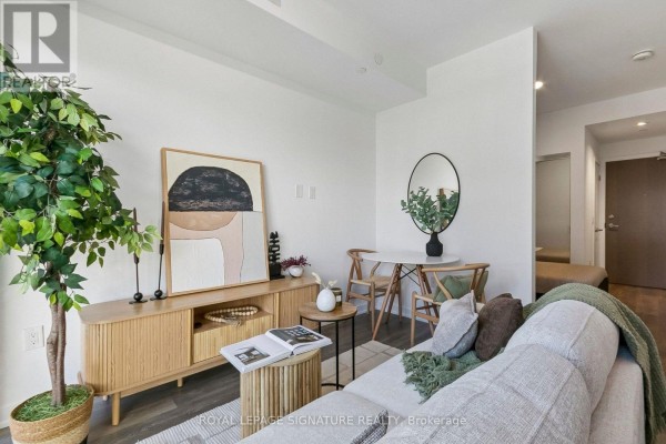 Bedroom with mirrored closet doors, king-size bed, and light wood laminate flooring. - 1006 - 20 Richardson Street, Toronto