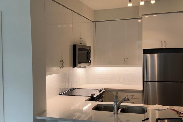 Bathroom with a white tub, tiled walls, and a toilet. - 1006 - 4955 Yonge Street, Toronto