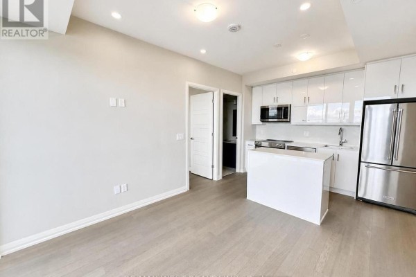 Empty room with a large window and sliding glass door overlooking the city. - 1007 - 3006 William Cutmore Boulevard, Oakville