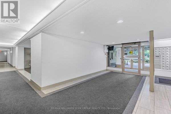 Apartment building lobby with grey carpet and mailboxes. - 1007 - 7811 Yonge Street, Markham