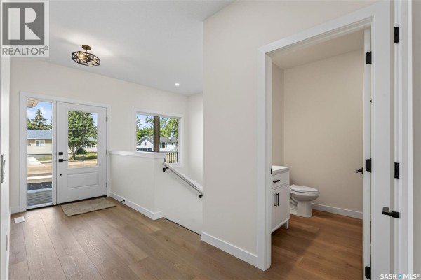 Entryway leading to a hallway with a visible half-bathroom containing a toilet and vanity. - 1008 10th Street, Humboldt
