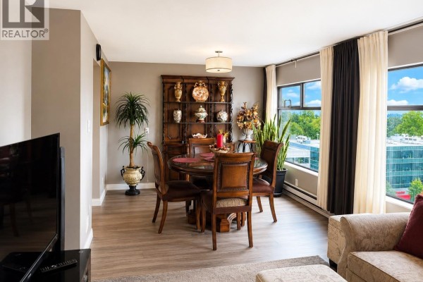 Dining area with a round wooden table, four chairs, a hutch, and large windows with curtains. - 1008 615 Belmont Street, New Westminster