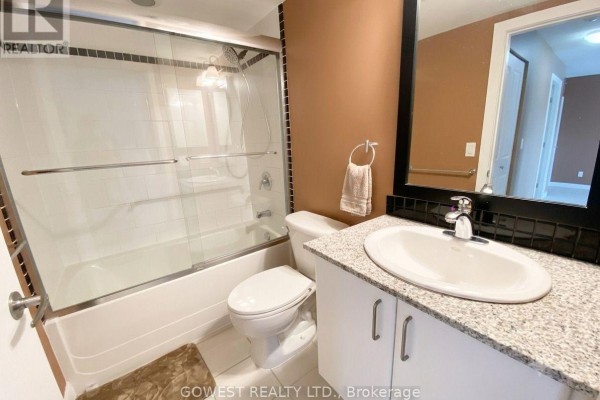 Bathroom with toilet, bathtub with shower, and vanity with granite countertop. - 1009 - 33 Sheppard Avenue E, Toronto