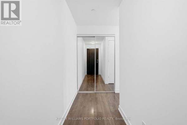 Entryway with view into kitchen area, hardwood flooring, and modern finishes - 1009 - 50 Bruyeres Mews, Toronto
