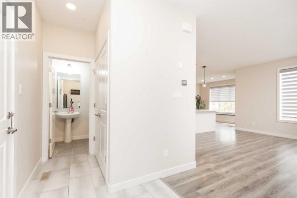 Laundry room with white front-load washer and dryer, white cabinets, and a countertop with tiled backsplash. - 1009 Atlantic Lookout W, Lethbridge