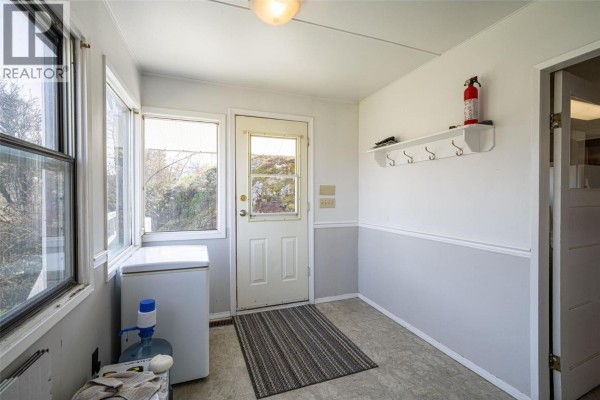 Kitchen with white cabinets, green countertops, stainless steel appliances, and a window above the sink. - 10091 6 Highway, Coldstream