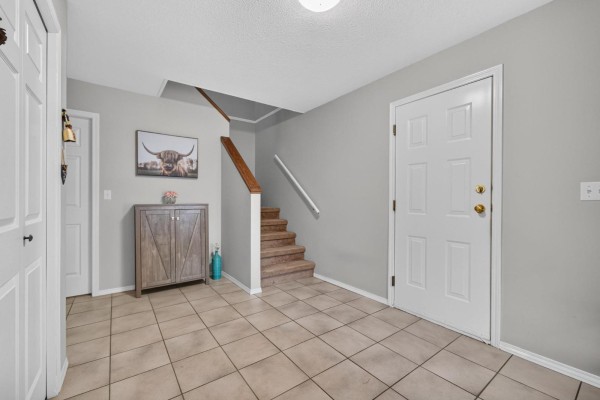 Living room with fireplace, television, couch, and bay window view. - 10097 Beaver Crescent, Little Mountain, Chilliwack