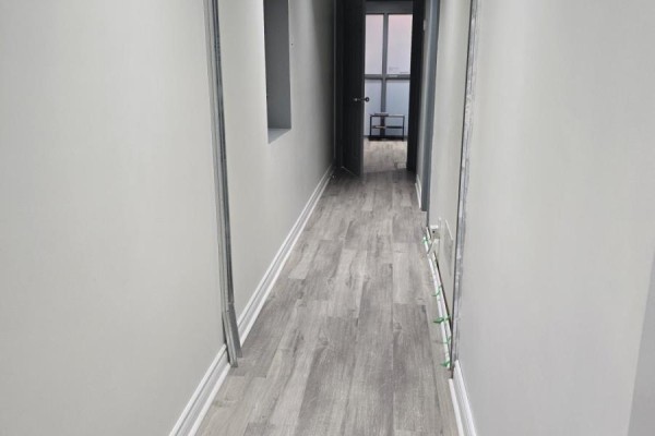 Long hallway with light wood flooring and a door leading to an exit - 100a - 253 Danforth Avenue, Toronto