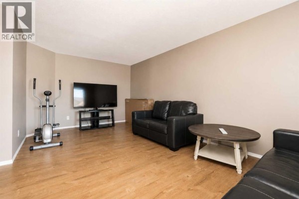 Dining room featuring a wooden table and chairs and double white doors. - 101,102,103,104, 10113 106 Avenue, Grande Prairie