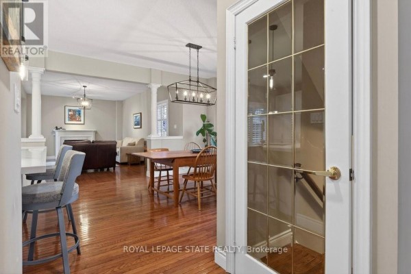 Open-concept living and dining area with hardwood floors and a glass-paned door. - 101 - 100 Beddoe Drive, Hamilton