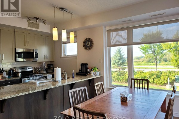 Kitchen with granite countertops and stainless steel appliances, adjacent to a dining area with window. - 101 - 130 Guelph Private, Ottawa