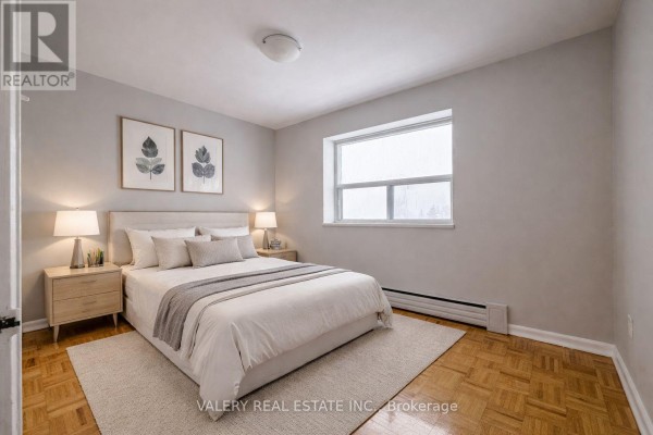 Bedroom with a queen-size bed, light wood nightstands, and a large window. - 101 - 1780 Lawrence Avenue E, Toronto