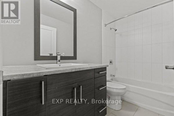 Bathroom with a modern vanity, white toilet, and tiled bathtub and shower. - 483 Linwell Road, St  Catharines