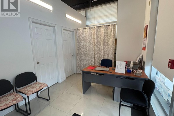 Reception area with a desk, chairs, and privacy curtain - 101 - 7130 Warden Avenue, Markham