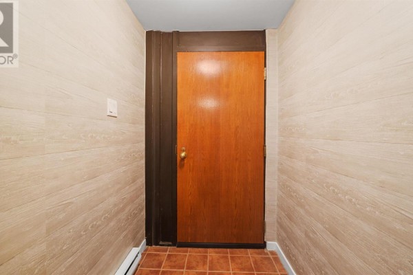 Apartment entrance hallway with a wooden door and tiled floor. - 101 1 Prince Street, Dartmouth