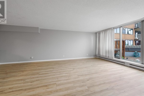 Living room with large windows, white curtains, and light wood flooring. - 101 1 Prince Street, Dartmouth