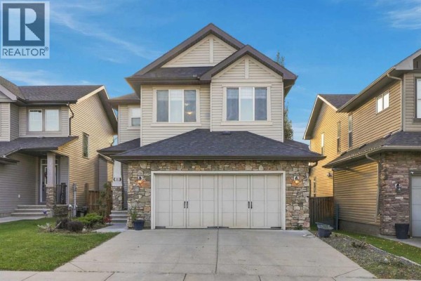 Two-story detached house with stone and siding exterior, two-car garage, and paved driveway. - 101 Cimarron Vista Crescent, Okotoks