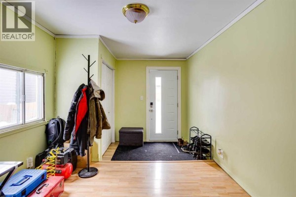 Entryway of a mobile home with pale green walls, closet, and a front door. - 101 Clausen Crescent, Fort Mcmurray