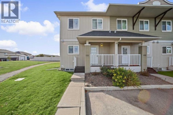 Front entrance of townhouses 101 and 102 with white railings and steps. - 101 Clover Way, Carstairs