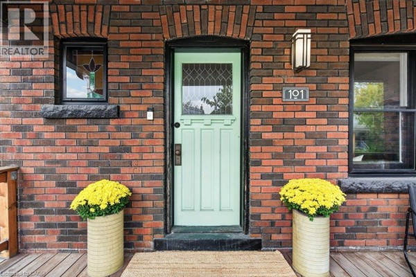 Detailed view of the light green front door, brick facade, stained glass window, and decorative house number '191'. - 101 Cope Street, Hamilton