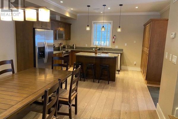 Dining area with wooden table, six chairs, and open layout to kitchen. - 101 Emerald Hill Court S, Seguin