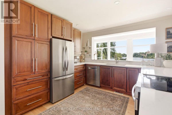 Kitchen features dark wood cabinets, stainless steel appliances, and white countertops. - 101 Patty Lane, Beckwith