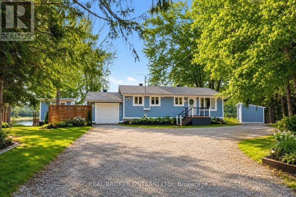 A blue residential house with a white garage door sits on a gravel driveway. - 101 Patty Lane, Beckwith